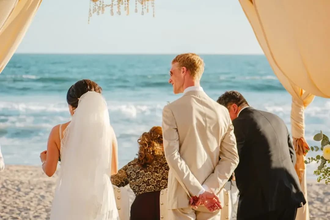Wedding ceremony on a beach with ocean backdrop.