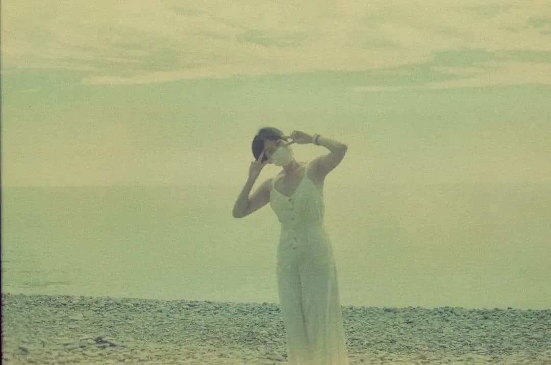 woman in white dress kissing man in black suit on beach during daytime