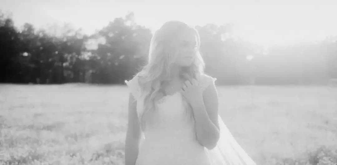 a woman in a dress standing in a field