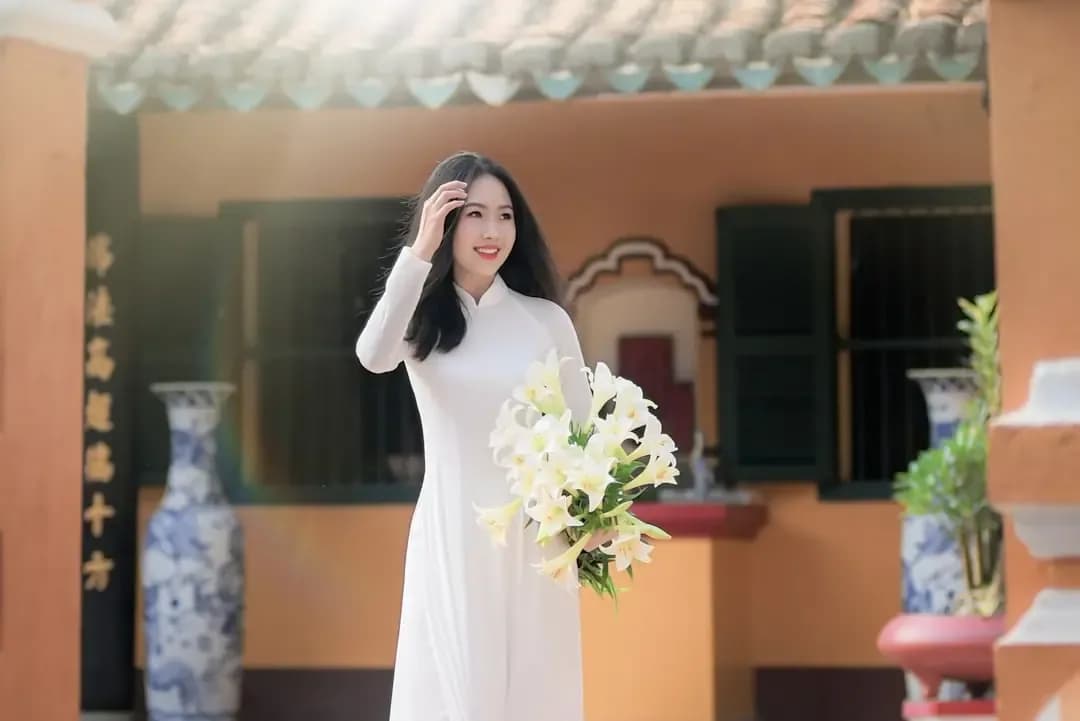woman in white dress holding white flower bouquet