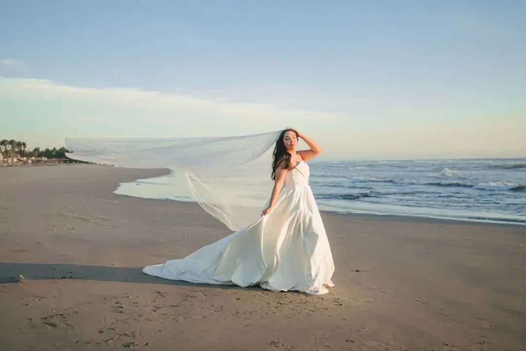 Bride in a flowing dress on a sandy beach