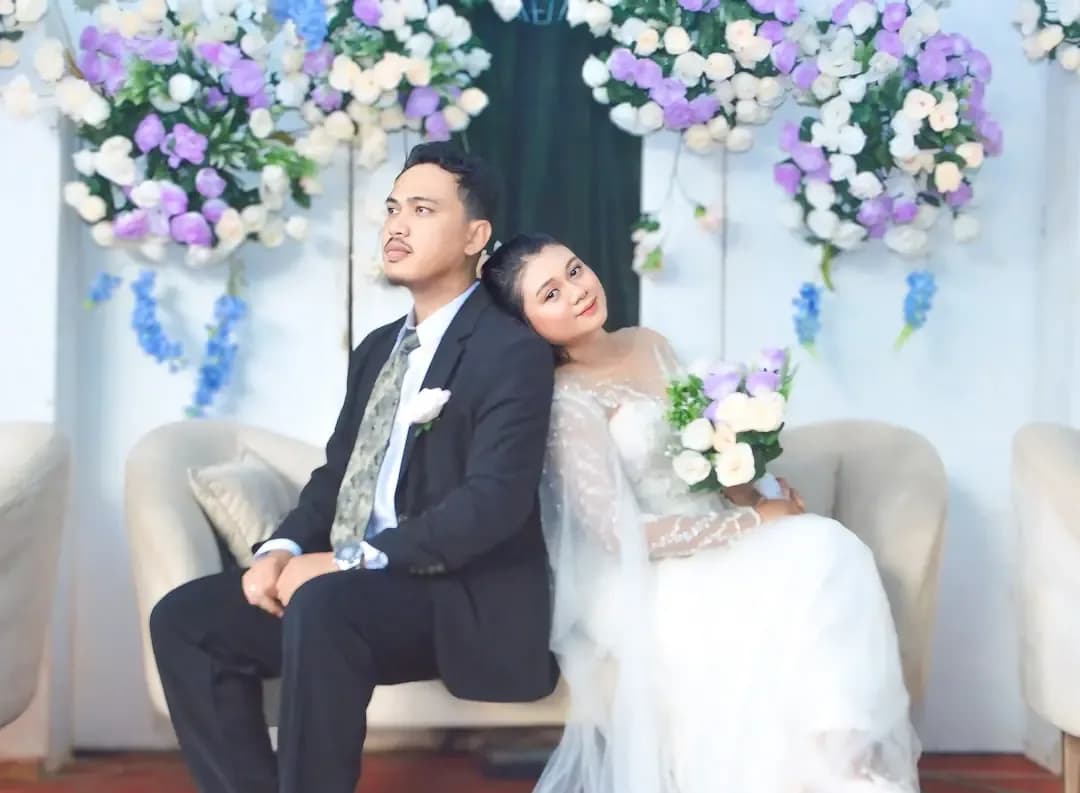 A newlywed couple poses for their wedding photos.