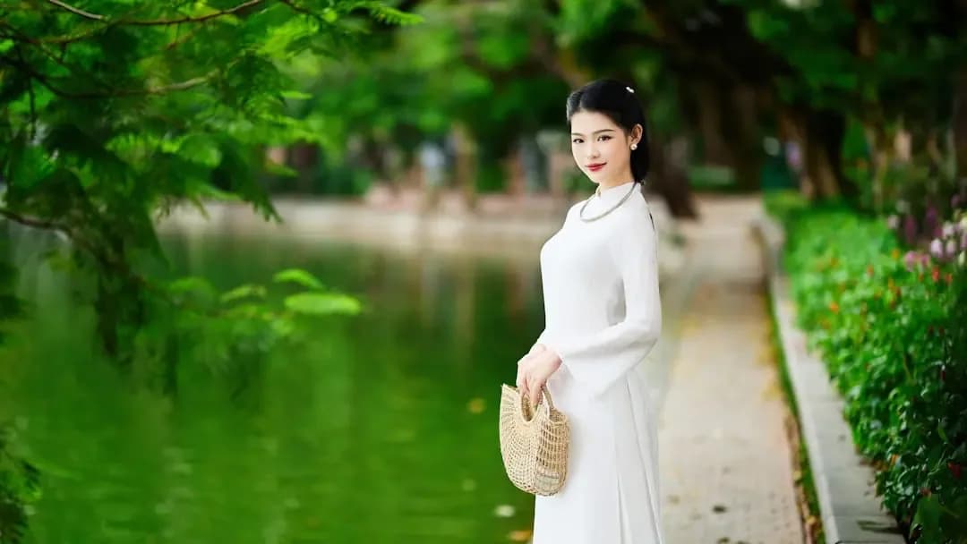 A young woman in a white dress by a lake