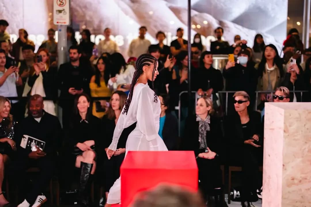Model walks runway with audience watching