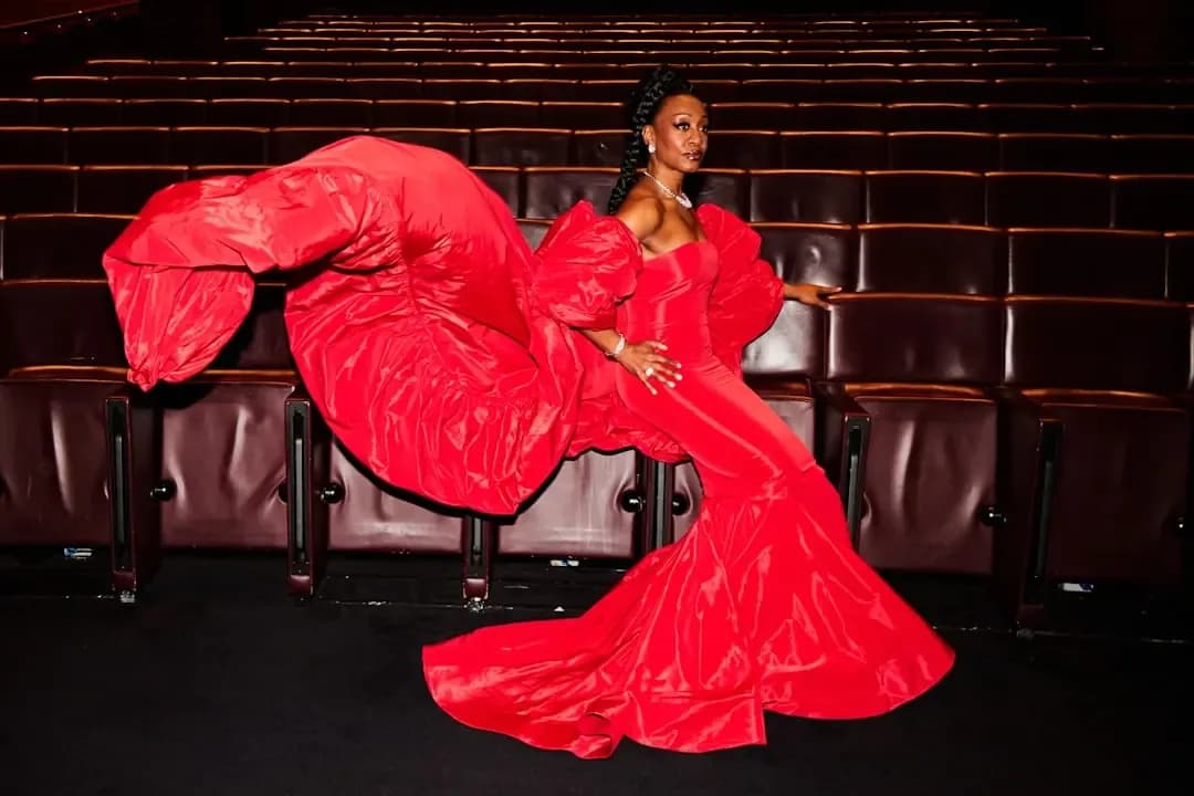 A woman in a red dress sitting on a chair