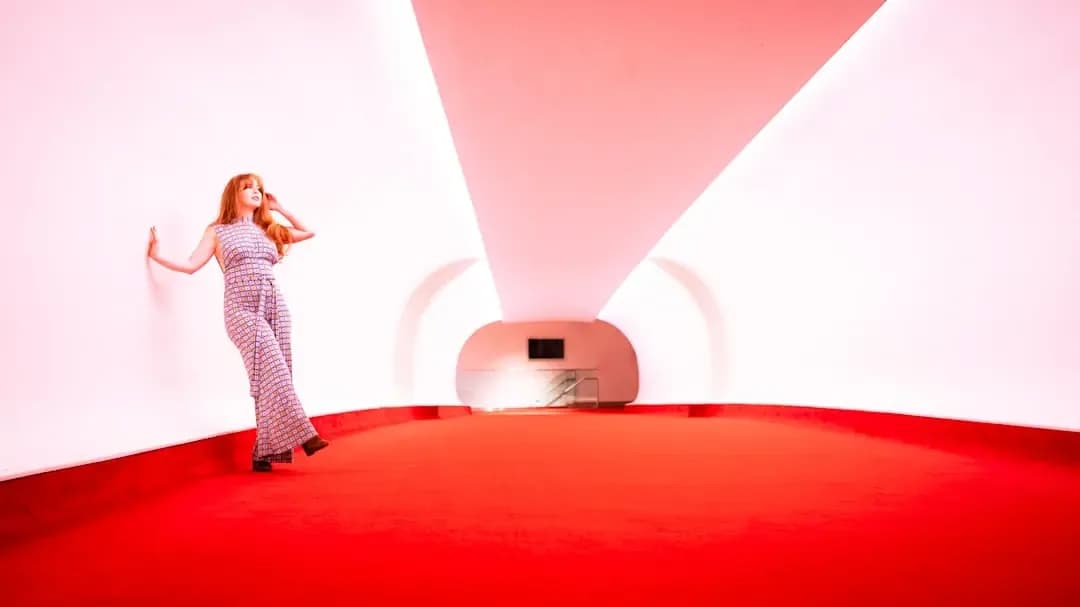 A woman standing in a room with a red carpet