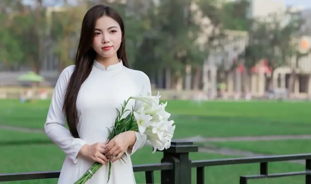 A woman in white dress holds a bouquet.