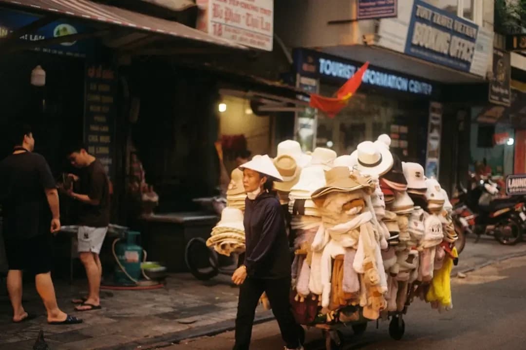 Vendor pushes cart full of hats and clothes on street