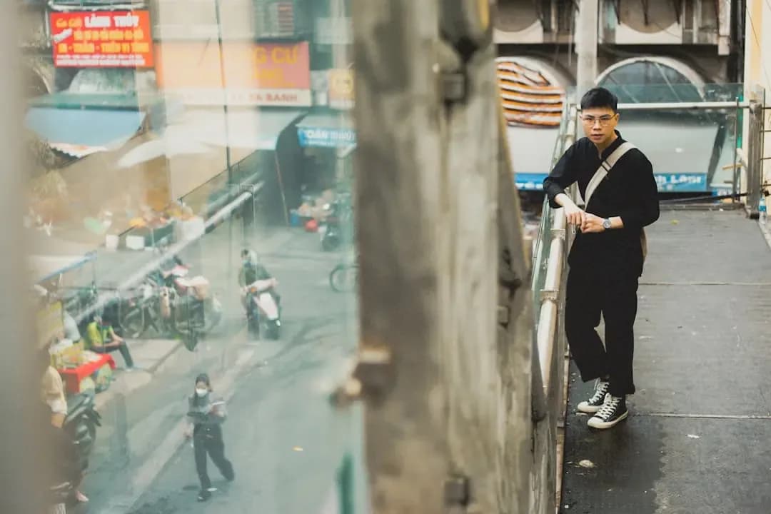 a man standing on a balcony next to a building