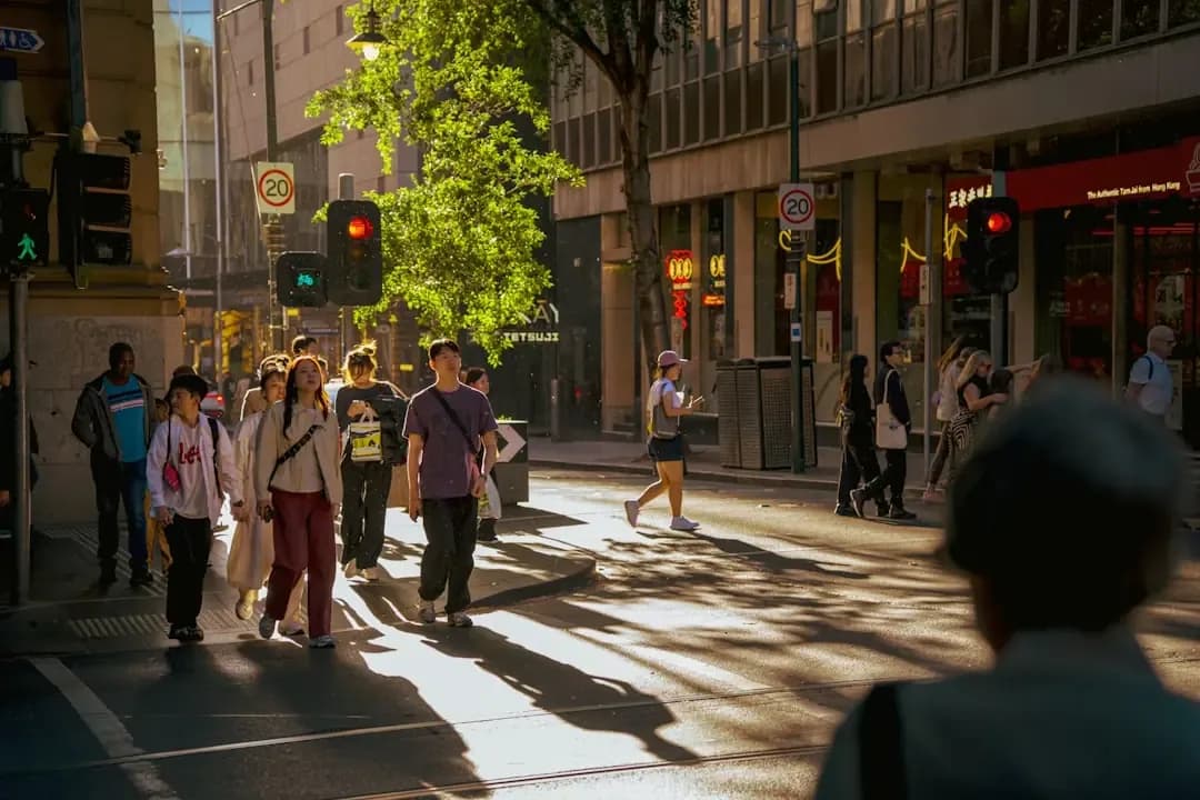 People crossing a sunlit city street