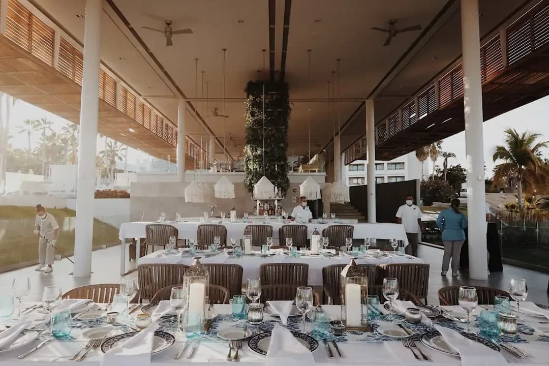 a dining area with tables, chairs, and a ceiling fan