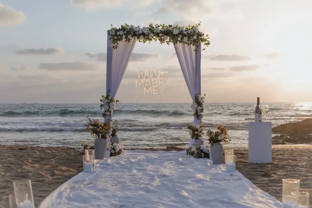 Wedding arch decorated with flowers on a beach.