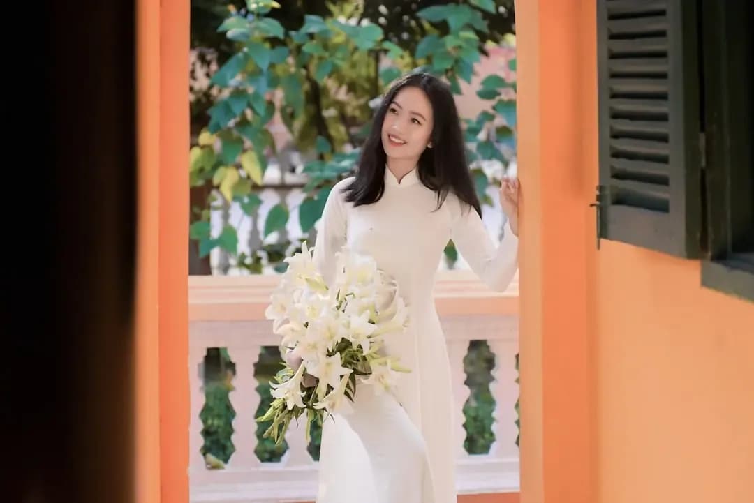 woman in white long sleeve dress holding white flower bouquet