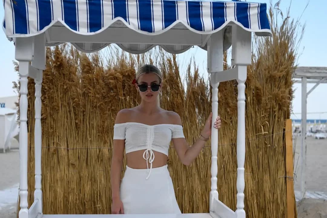 Woman in white outfit standing at beach kiosk
