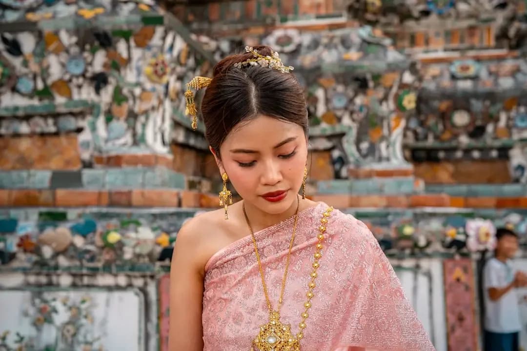 Woman in traditional thai dress with ornate background